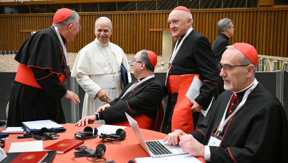 Papst Leo XIV. im Gespräch mit Kardinälen beim außerordentlichen Konsistorium am 8. Januar 2026 im Vatikan. Rechts am Tisch sitzt Kardinal Pierbattista Pizzaballa, lateinischer Patriarch von Jerusalem, und arbeitet am Laptop.