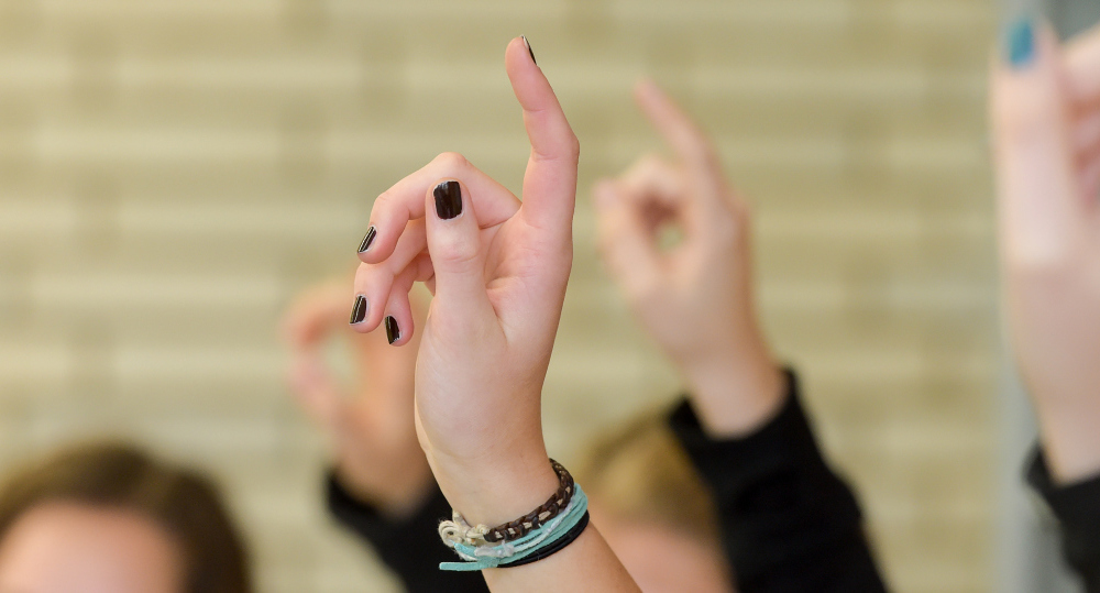 Evangelischer Religionsunterricht in einem Berufskolleg in Bonn. Schüler melden sich. Hinweis: Model-Release ist vorhanden.